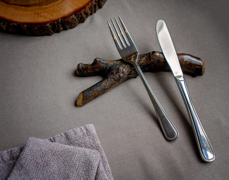 Knife and fork resting on a tree branch as part of table decoration in a bush food restaurant