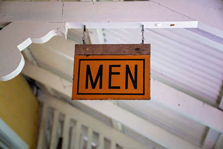 Vintage signage hanging from the ceiling indicating male bathroomの写真素材