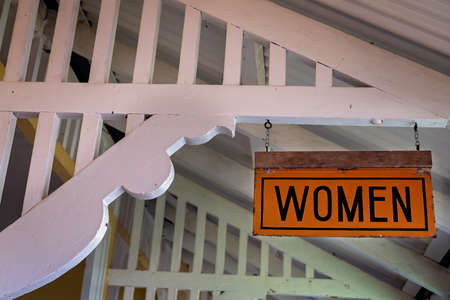 A vintage sign indicating washroom fro women hanging from rafters of retro houseの写真素材