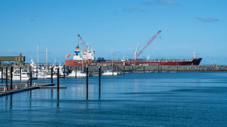 Mackay, Queensland, Australia - January 2021: Luxury boats moored in the marina with a container ship in the backgroundのeditorial素材
