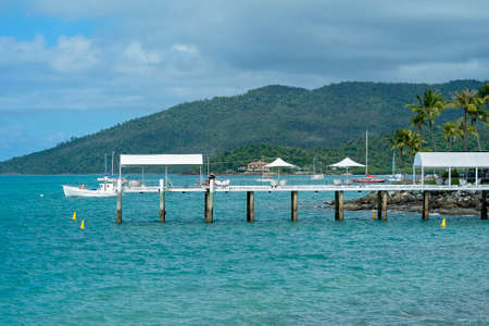 Airlie Beach, Queensland, Australia - February 2021: Tourists relaxing under umbrellas on a jetty over the water on a bright sunny dayのeditorial素材