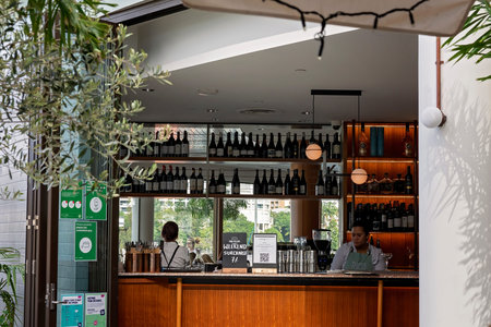 Brisbane, Queensland, Australia - March 2021: Female staff tending bar in a city restaurant
