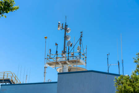 Mackay, Queensland, Australia - March 2021: Communications technology equipment on roof top against a blue skyのeditorial素材