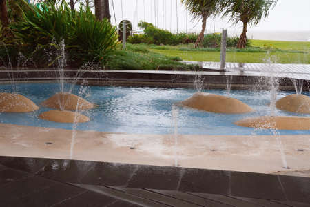 A children's wading pool with water spouts from artificial rocksの写真素材