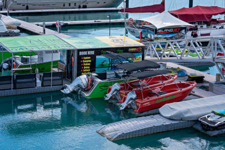 Airlie Beach, Queensland, Australia - April 2021: Water sports booking office and tourist boats for hire at Coral Sea Marinaのeditorial素材