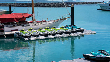 Airlie Beach, Queensland, Australia - April 2021: Jet skis for hire lined up on a pontoon in front...