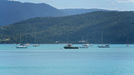 Airlie Beach, Queensland, Australia - April 2021: Boats anchored off shore in a bay of water with hillside backgroundのeditorial素材