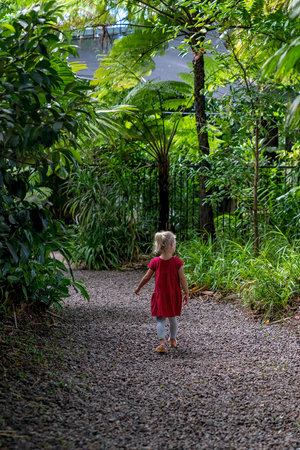 Mackay, Queensland, Australia - June 2021: A young girl walking on a path through the local botanic gardens exploring the floraのeditorial素材