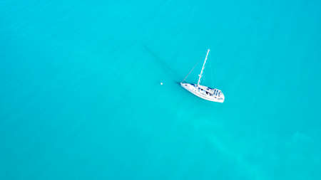 Aerial view on top of a white yacht anchored alone in the turquoise ocean of the Coral Seaの写真素材