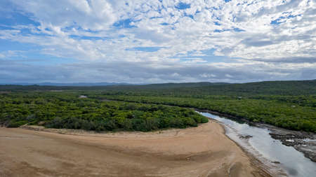 The beach beside a creek at low tide with a cloudy blue sky, aerial view of Cape Palmerston Australiaの写真素材