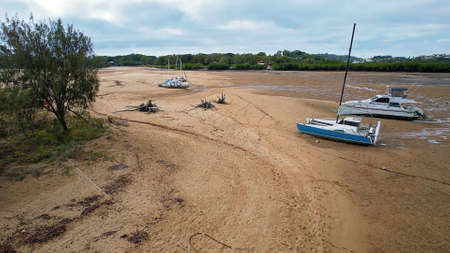 Mackay, Queensland, Australia - July 2021: Boats moored in a creek at low tide on Bucasia Beachのeditorial素材