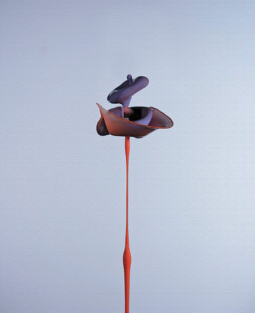 An artistic shape in blue and orange water drops shot from above and below to form a collision,...