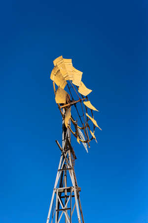 An old style country windmill etched against a clear deep blue skyの写真素材