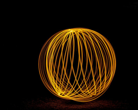 Light painting of a ball shape resulting in an orange glow against a black background
