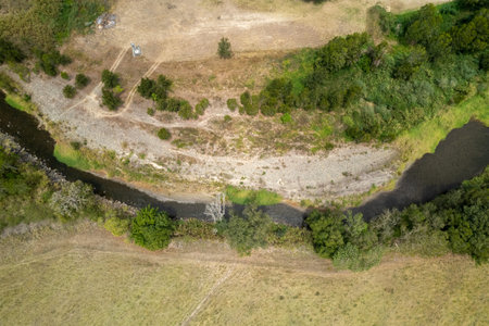 Creek winding through country landscape, drone aerial high perspective viewの写真素材