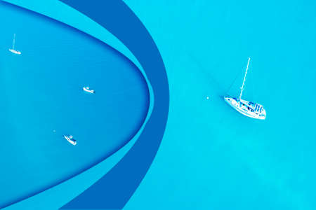 Aerial view on top of a white yacht anchored alone in the turquoise ocean of the Coral Sea with paper curl of two yachts on blue sea, ideal tourism flierの写真素材