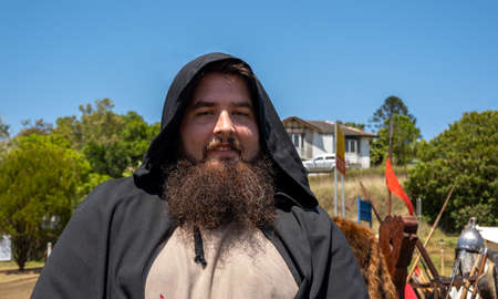 Eungella, Queensland, Australia - October 2021: A bearded man in black hooded costume at a medieval viking village re-enactment in the countryのeditorial素材