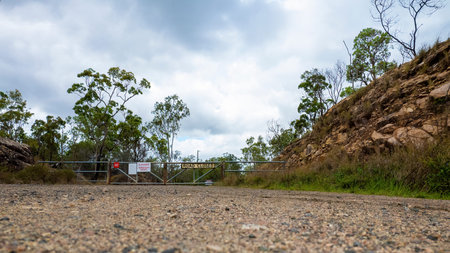 Low down capture of a closed gate with signage indicating the road is closed and there is to be no...