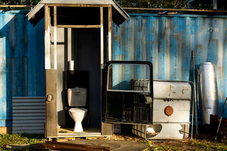 A unique backyard toilet with car door in early morning sunlight and shadowsの写真素材