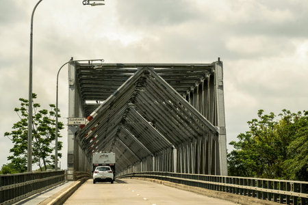Townsville to Mackay highway, Queensland, Australia - November 2021: Vehicles driving on highway with large steel bridge crossing a riverのeditorial素材