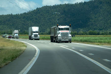 Bruce Highway Townsville to Mackay, Queensland, Australia - November 2021: Three semi trailer trucks carting cargo on the highwayのeditorial素材