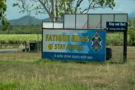 Bruce Highway, Townsville to Mackay, Queensland, Australia - November 2021: Road safety message sign that fatigue kills stay awakeのeditorial素材