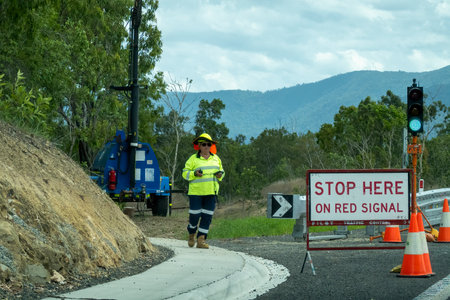 Bruce Highway, Townsville to Mackay, Queensland, Australia - November 2021: Female traffic controller at work on road construction siteのeditorial素材