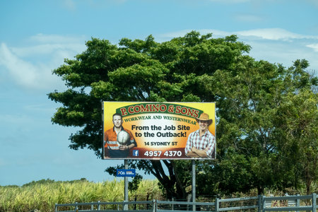 Bruce Highway, Townsville to Mackay, Queensland, Australia - November 2021: Local work wear and western wear clothing store advertising roadside billboardのeditorial素材