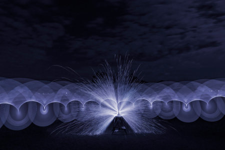 Light painting waving a light stick across an angle grinder forming a butterfly shape against a...