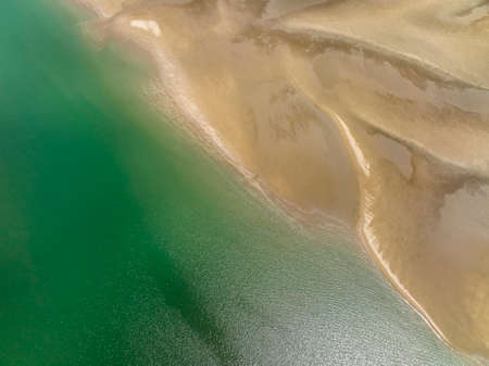 Patterns in the sand of the ocean bed at low tide on a beach, drone aerial patternの写真素材