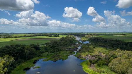 High drone aerial downriver from a dam with small flows of water through bushland. Dumbleton Weir,...