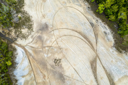 Overhead drone view of salt flats vegetation with tyre marks from cars and motor bikes .の写真素材