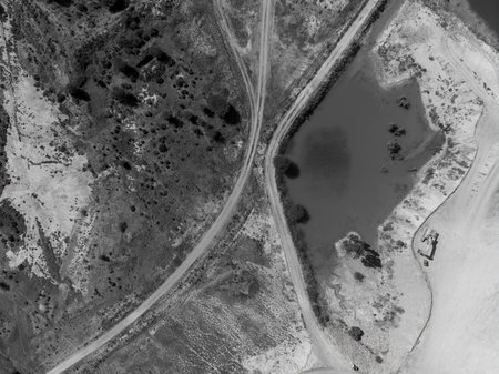 Drone aerial over ponds of water and dirt tracks caused by sapphire miners in central Queensland,...