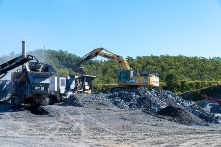 Mackay, Queensland, Australia - 7th June 2022: Machinery working in a quarry producing industrial...