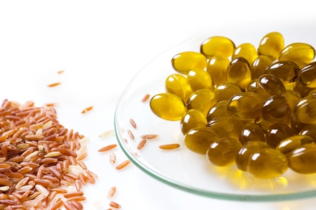 transparent pills of vitamin E on dish and riceの写真素材