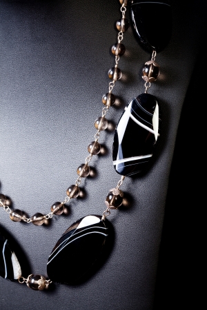 luxury jewellery pearl and black stone set necklace over black backgroundの写真素材