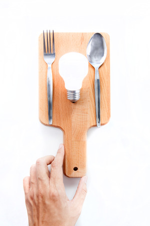 Light bulb on chopping board, serve idea concept, white backgroundの写真素材