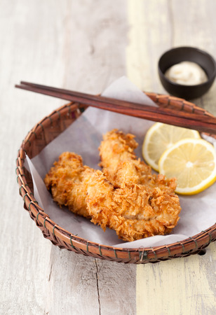 Fried Chicken with sauce in a basket on a wooden table, Selective focusの写真素材