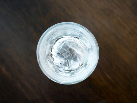 Glasses with ice cubes on wooden tableの写真素材