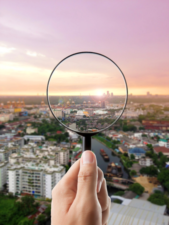 Magnifying glass and cityscape in focus, business visionの写真素材