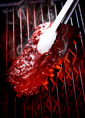 Close up of Smoked Barbecue Pork Spare Ribs on hot flaming grill, selective focusの写真素材
