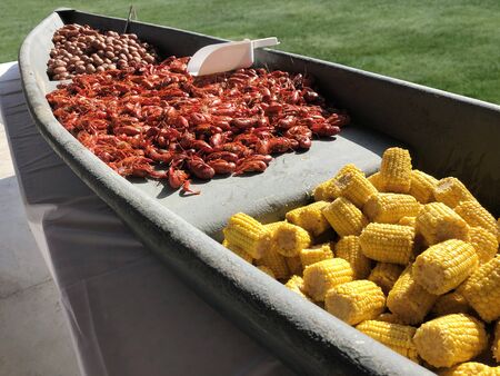 A crawfish boil serving with corn and boiled potatoes in a boatの写真素材