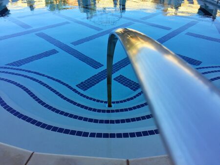 A luxurious swimming pool at sunsetの写真素材