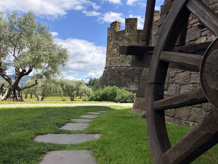 A wagon wheel in front of a majestic castle on a warm summer dayの写真素材
