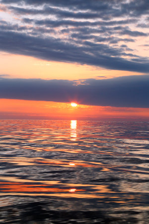 A colorful sunset over the water horizonの写真素材