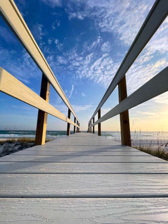 Looking up at the long pier heading towards the beach in Destin, Florida on a warm summer eveningの写真素材