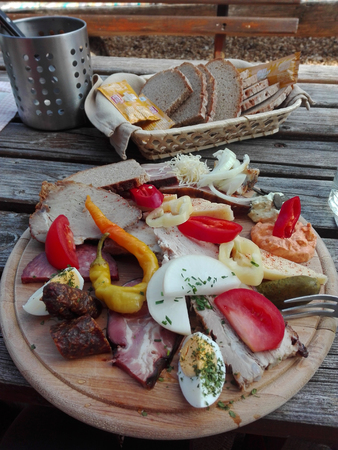 Traditional Brettljausn with bread and a lot of cold cuts on wooden table in Austriaの写真素材