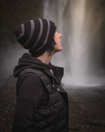 Beautiful Girl Enjoying Nature and a Waterfallの写真素材