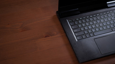 Dark black laptop keyboard off-screen on wooden tableの写真素材