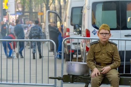 MOSCOW, RUSSIA - MAY 9, 2019: Immortal regiment procession in Victory Day. A soldier child looking at camera posed while sitting with a indifferent faceのeditorial素材